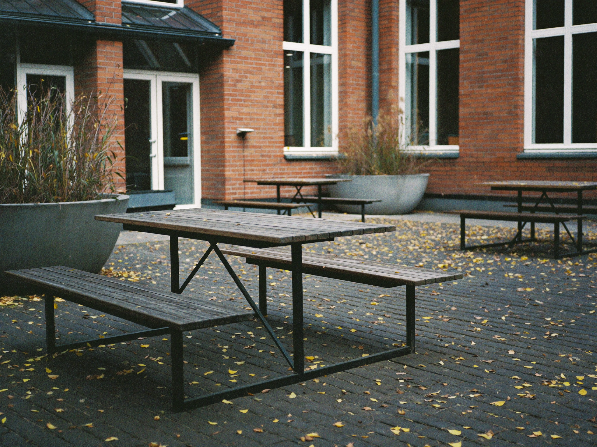 Piknikbord i tre i en skolegård