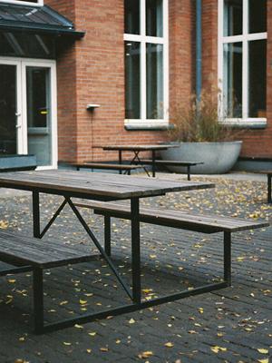 Piknikbord i tre i en skolegård