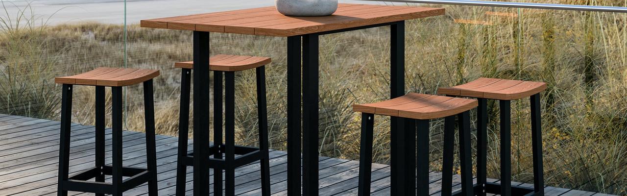 Barbord och barstolar i teak och aluminium på en altan vid havet