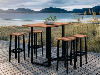 Barbord och barstolar i teak och aluminium på en altan vid havet